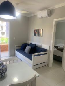 Un dormitorio con una cama con almohadas azules. en Boulevard Riviera Flat, en Riviera de São Lourenço