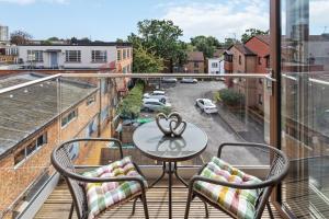 a balcony with a table and two chairs at Elegant Living in Kingston: Two Bedroom Apartment in Kingston upon Thames