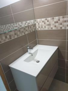 ein Badezimmer mit einem weißen Waschbecken und einem Spiegel in der Unterkunft A ka lé Mich in Sainte-Rose