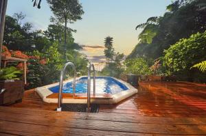 una bañera de hidromasaje en una terraza con vistas en Magic Mena Rainforest Retreat en Mena Creek