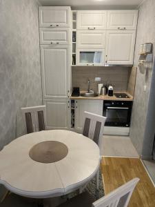 uma cozinha branca com uma mesa e cadeiras em Adriatic apartman em Budva