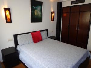 een slaapkamer met een bed met een rood kussen bij Casablanca in Casablanca