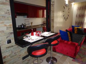 Casablanca في الدار البيضاء: غرفة معيشة مع طاولة وأريكة حمراء