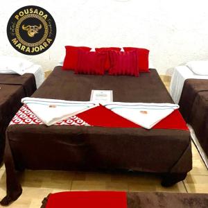 a large bed with red pillows on top of it at Pousada Marajoara- Hotel Fazenda-Turismo de Aventura in Soure