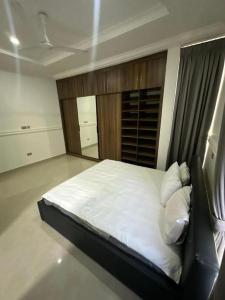 Schlafzimmer mit einem Bett mit weißer Bettwäsche und Kissen in der Unterkunft Hanaila Homes in Ogbojo