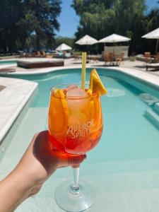 a person holding a margarita in a glass next to a pool at Hotel Chapaqñan in Villa Rumipal