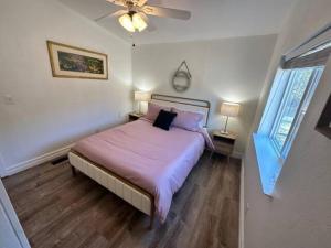 a bedroom with a bed and a ceiling fan at Enchanting Getaway Farmhouse And Tiny House Duo in Jacksonville