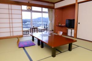 a living room with a table and a large window at Kishotei in Hirado