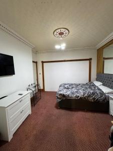 a bedroom with a bed and a flat screen tv at Crete home in Oldham