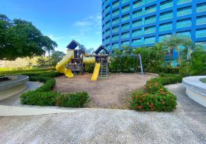 a playground in front of a tall building at Bahiamar in Pampatar