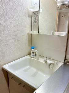 a bathroom with a white sink and a mirror at KANAU in Tokyo