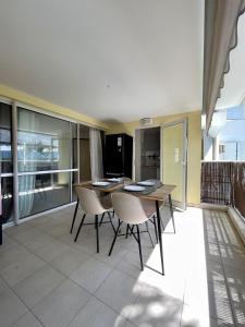 a dining room with a table and chairs at Appartement cosy en ville in Baie-Mahault