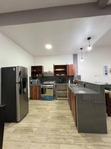 弗洛雷斯的住宿－Casa G&V x 8 personas，厨房配有不锈钢冰箱和木制橱柜