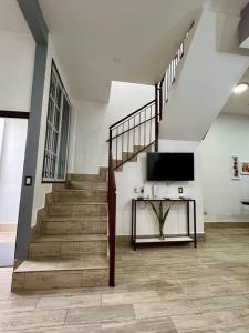 a room with a staircase with a television and a table at Casa G&V x 8 personas in Flores +19 photos