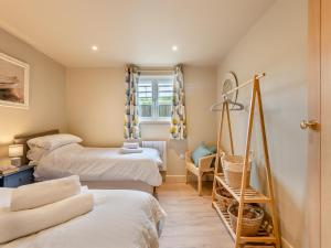 Habitación con 3 camas, silla y ventana en Swallow Barn en Bigbury-on-Sea
