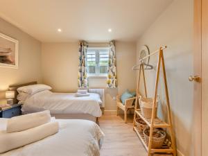 a room with three beds and a chair and a window at Swallow Barn in Bigbury on Sea