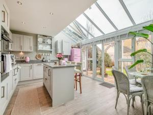 a kitchen with white cabinets and a glass ceiling at Dukes House in Corsham