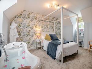 ein Schlafzimmer mit einem Bett und einer Badewanne neben einem Bett und einer Badewanne in der Unterkunft Dukes House in Corsham
