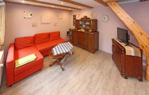 - un salon avec un canapé rouge et une télévision dans l'établissement Nice Home In Ribnitz-damgarten With Kitchen, à Ribnitz-Damgarten