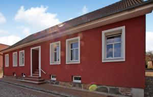 une maison rouge avec des fenêtres blanches sur une rue dans l'établissement Lovely Apartment In Rheinsberg Ot Flecken With Kitchen, à Flecken Zechlin