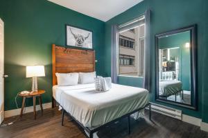 Dormitorio verde con cama y espejo en Oxford Apartment by At Mine Hospitality en Seattle