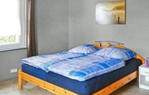 a bed with a blue comforter in a bedroom at Amazing Home In Mirow Ot Qualzow With Wifi in Qualzow