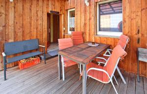 einen Holztisch und Stühle auf einer Holzterrasse in der Unterkunft 1 Bedroom Amazing Apartment In Silz in Silz
