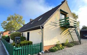 a small house with a green fence in front of it at Beautiful Apartment In Ueckermnde seebad With Wifi in Neuendorf