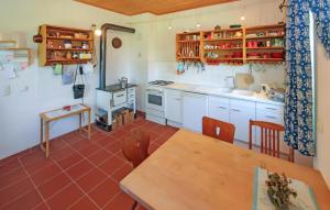 uma cozinha com armários brancos e uma mesa de madeira em Stunning Home In Penzlin Ot Krukow With Kitchen em Mallin