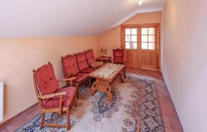 een woonkamer met rode stoelen en een tafel bij 4 Bedroom Amazing Apartment In Kuchelmi in Kuchelmiß