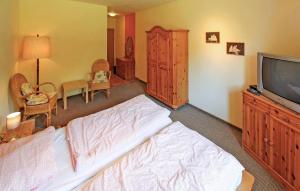 een slaapkamer met een bed en een tv en een kamer bij 4 Bedroom Amazing Apartment In Kuchelmi in Kuchelmiß