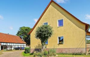 a yellow house with a tree in front of it at Cozy Apartment In Kieve With Wifi in Kieve