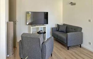 un soggiorno con divano, sedia e TV di 1 Bedroom Lovely Apartment In Poseritz a Poseritz
