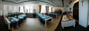 a dining room with tables with blue and white table settings at Hotel Wojtyla in Međugorje