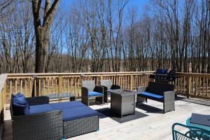 a deck with chairs and a grill and trees at Long pond, Pocono pines quiet & cozy!Kalahari 8mins in Pocono Pines