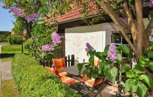 a table and chairs in front of a house with flowers at Beautiful Home In Grnow With Wifi in Grünow