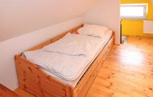 a bed in a room with a wooden floor at Amazing Home In Zettemin Ot Rtzenfeld With Kitchen in Varchentin