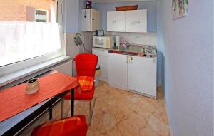 uma pequena cozinha com cadeiras vermelhas e um lavatório em 1 Bedroom Stunning Home In Waren mritz em Kölpinsee