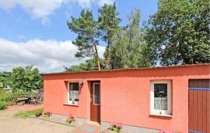 a red house with a tree on top of it at 1 Bedroom Stunning Home In Waren mritz in Kölpinsee