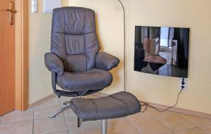 una sedia in pelle marrone e uno sgabello in una stanza di Lovely Apartment In Zempin seebad With Kitchen a Zinnowitz
