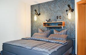 a bedroom with a blue bed with pillows on it at Cozy Home In Waren mritz With Kitchen in Kölpinsee