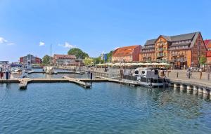 a marina with boats in the water next to buildings at Cozy Home In Waren mritz With Kitchen in Kölpinsee