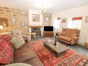 a living room with a couch and chairs and a fireplace at Parkers House in Alston