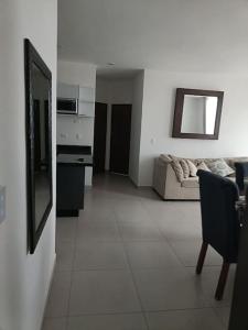 een woonkamer met een bank en een tafel bij Departamento coto privado con alberca in Mazatlán