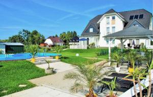 a large white house with a yard with palm trees at Beautiful Apartment In Neppermin-usedom With Wifi in Neppermin