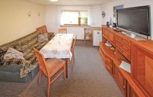ein Wohnzimmer mit einem TV und einem Tisch mit Stühlen in der Unterkunft Awesome Apartment In Zinnowitz seebad With Kitchen in Zinnowitz