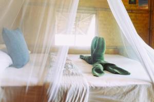 Bamboo Bay Island Resort في سورات ثاني: سرير عليه قفازات خضراء