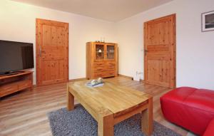 een woonkamer met een tafel en een rode bank bij Lovely Apartment In Userin With Kitchen in Userin