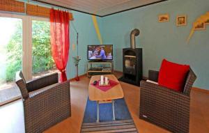 克品希的住宿－Cozy Home In Waren mritz With Kitchen，客厅配有两把椅子、一张桌子和电视