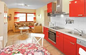 een keuken met rode kasten en een woonkamer bij Awesome Apartment In Zislow With Kitchen in Zislow